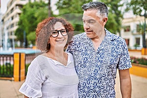 Middle age hispanic couple together outdoors on summer day