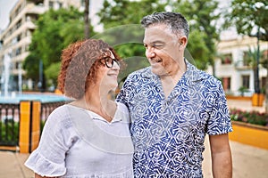 Middle age hispanic couple together outdoors on summer day