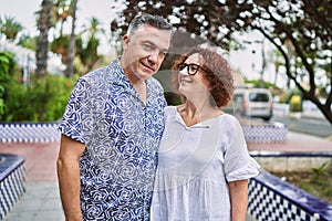 Middle age hispanic couple together outdoors on summer day