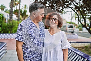 Middle age hispanic couple together outdoors on summer day