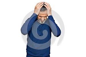 Middle age hispanic man wearing casual clothes suffering from headache desperate and stressed because pain and migraine