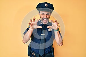 Middle age hispanic man wearing police uniform smiling funny doing claw gesture as cat, aggressive and sexy expression