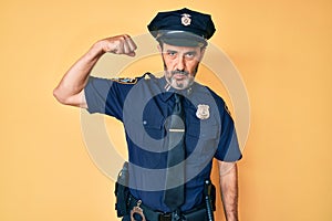 Middle age hispanic man wearing police uniform strong person showing arm muscle, confident and proud of power