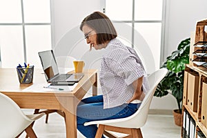 Middle age hispanic woman businesswoman with backache at business office