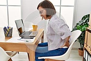 Middle age hispanic woman businesswoman with backache at business office