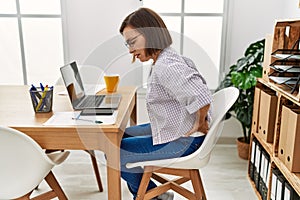 Middle age hispanic woman businesswoman with backache at business office