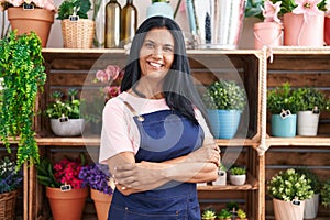 Middle age hispanic woman florist smiling confident standing with arms crossed gesture at florist