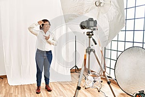 Middle age hispanic woman posing as model at photography studio smiling making frame with hands and fingers with happy face