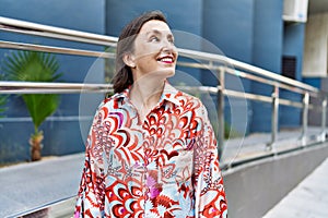 Middle age hispanic woman smiling happy and confident outdoors at the city