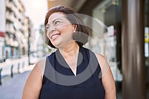 Middle age hispanic woman smiling happy and confident outdoors on a sunny day