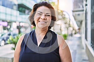 Middle age hispanic woman smiling happy and confident outdoors on a sunny day