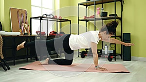 Middle age hispanic woman training core exercise at sport center