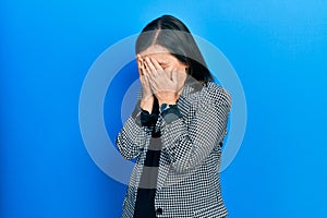 Middle age hispanic woman wearing business clothes with sad expression covering face with hands while crying