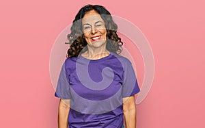 Middle age hispanic woman wearing casual clothes winking looking at the camera with sexy expression, cheerful and happy face