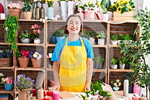Middle age hispanic woman working at florist shop with a happy and cool smile on face