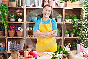 Middle age hispanic woman working at florist shop happy face smiling with crossed arms looking at the camera