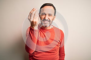 Middle age hoary man wearing casual orange sweater standing over isolated white background Doing Italian gesture with hand and