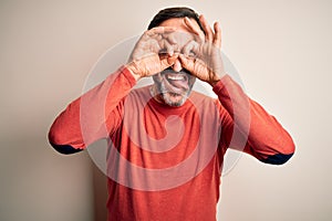 Middle age hoary man wearing casual orange sweater standing over isolated white background doing ok gesture like binoculars