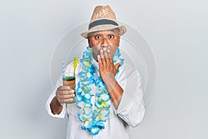 Middle age latin man wearing summer style drinking mojito glass covering mouth with hand, shocked and afraid for mistake