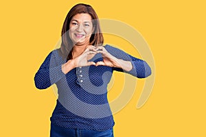 Middle age latin woman wearing casual clothes smiling in love showing heart symbol and shape with hands