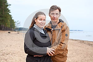 Middle age loving couple portrait standing together on coastline
