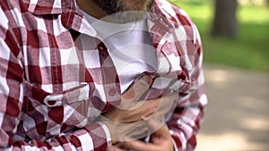 Middle-age male feeling strong chest pain, sensation of tightness, heart attack photo