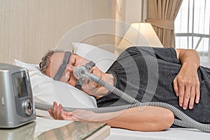 Middle age male with sleep apnea wearing CPAP headgear and mask while sleeping