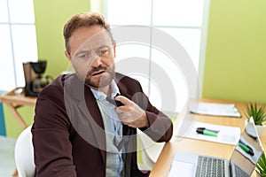 Middle age man business worker loosen tie working at office