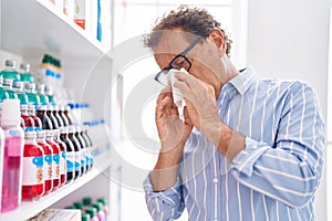 Middle age man customer using napkin at pharmacy
