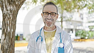 Middle age man doctor smiling confident standing at park