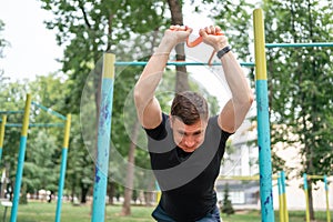 Middle age man doing strength exercises with resistance bands outdoors in park