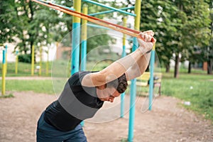 Middle age man doing strength exercises with resistance bands outdoors in park