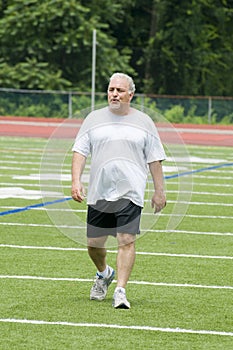 Middle age man exercising on sports field