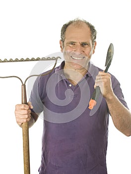 Middle age man gardener spade and bow rake tools