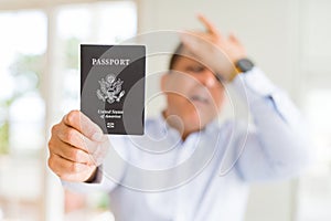 Middle age man holding holding passport of United States stressed with hand on head, shocked with shame and surprise face, angry
