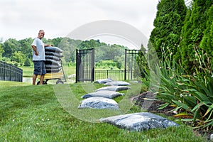 Middle Age Man Mulching his House Backyard