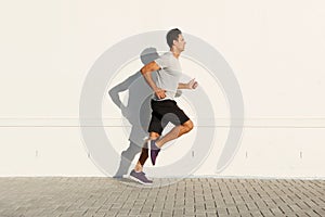 Middle age man running by white wall