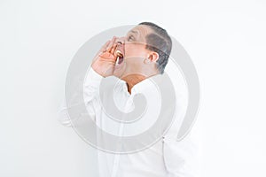 Middle age man shouting crazy with hands over mouth over white wall background