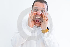 Middle age man shouting crazy with hands over mouth over white wall background