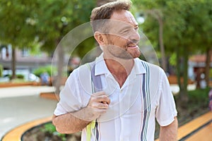 Middle age man smiling confident looking to the side at park