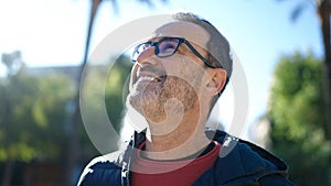 Middle age man smiling confident looking to the sky at park