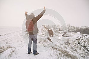 Middle age man standing in beautiful winter landscape . Man viewing on abandoned freestyle motocross ramps. Add color