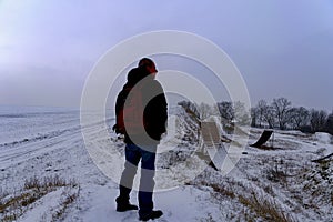 Middle age man standing in winter landscape during sunsrise