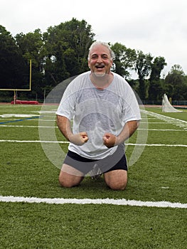 Middle age man stretching sports field