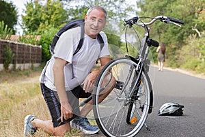 Middle-age man using hand air pump for bike