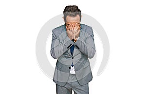 Middle age man wearing business clothes with sad expression covering face with hands while crying