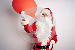 Middle age man wearing Santa costume holding speech bubble over isolated white background with a confident expression on smart