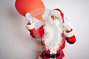 Middle age man wearing Santa costume holding speech bubble over isolated white background doing ok sign with fingers, excellent