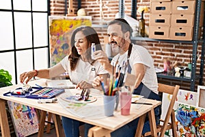 Middle age man and woman artists drawing on notebook at art studio