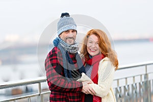 Middle age man and woman smiling on street. Joyful woman and guy. Smiling couple on street in winter wear